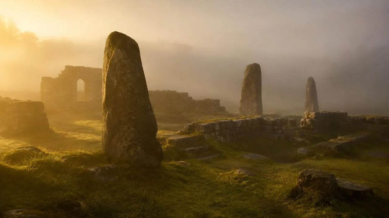 Ancient standing stones and ruins in morning fog